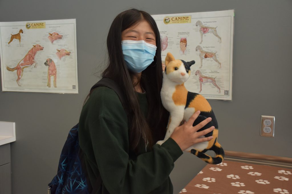 A student smiles with a stuffed cat at CSU SPUR