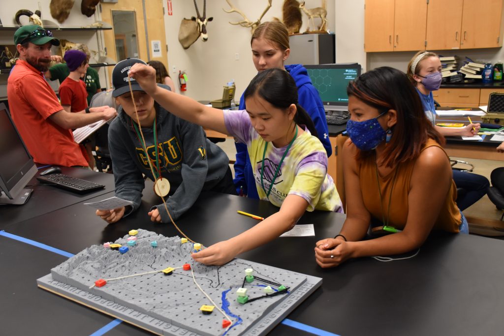 Four students work together on a STEM kit