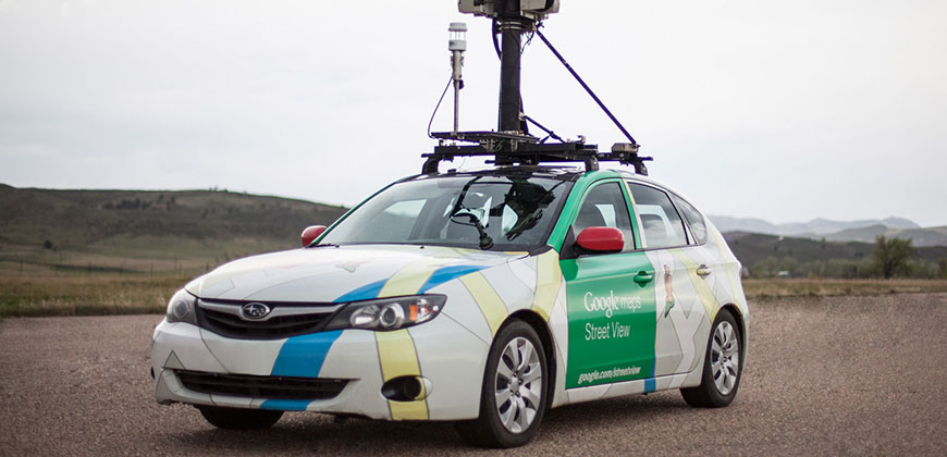 A Google Maps car sits on a road. A large pole comes out from the top of it.