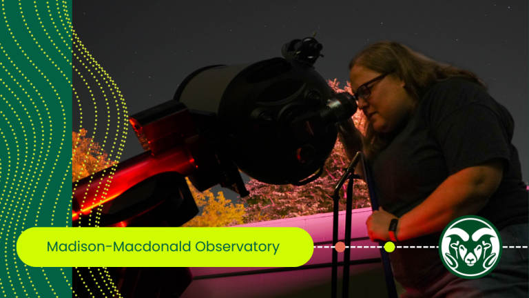 A person looks through a telescope into the night sky.