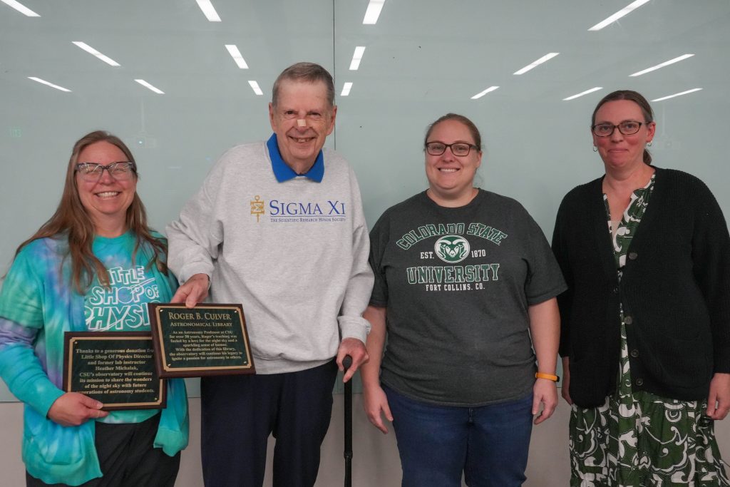 Heather Michalak and Roger Culver accept awards from Emily Hardegree-Ullman and Physics Department Chair Kristen Buchanan. 